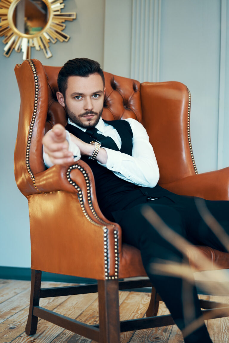 Confident young man relax in armchair in luxury interior